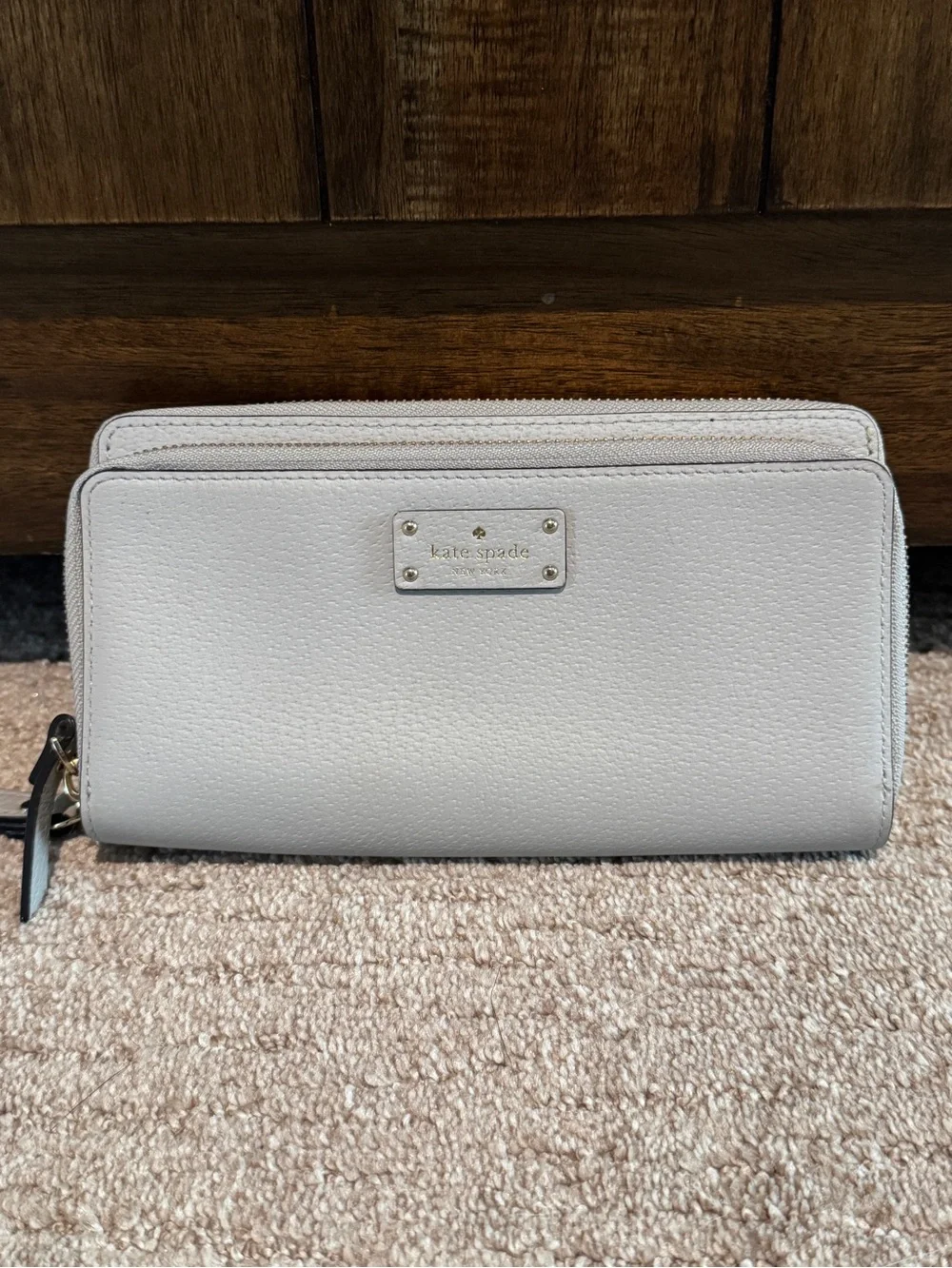 Kate Spade light gray zip-around wristlet wallet with gold logo